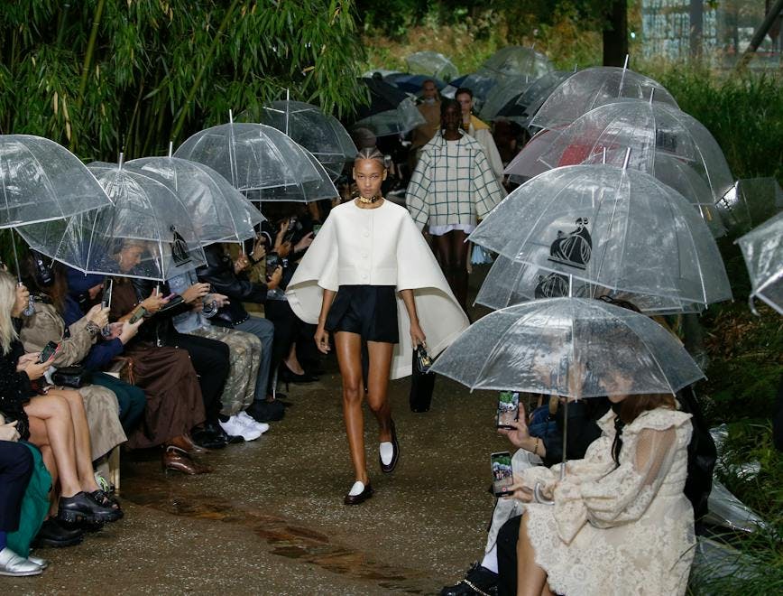 clothing apparel person human shorts umbrella canopy shoe footwear helmet