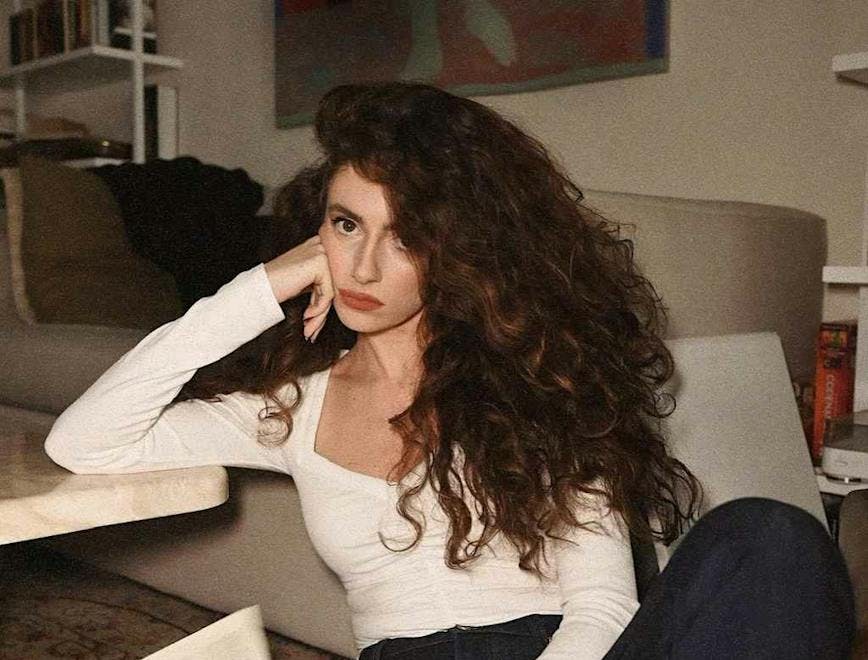 clothing pants person sitting face head curly hair hair