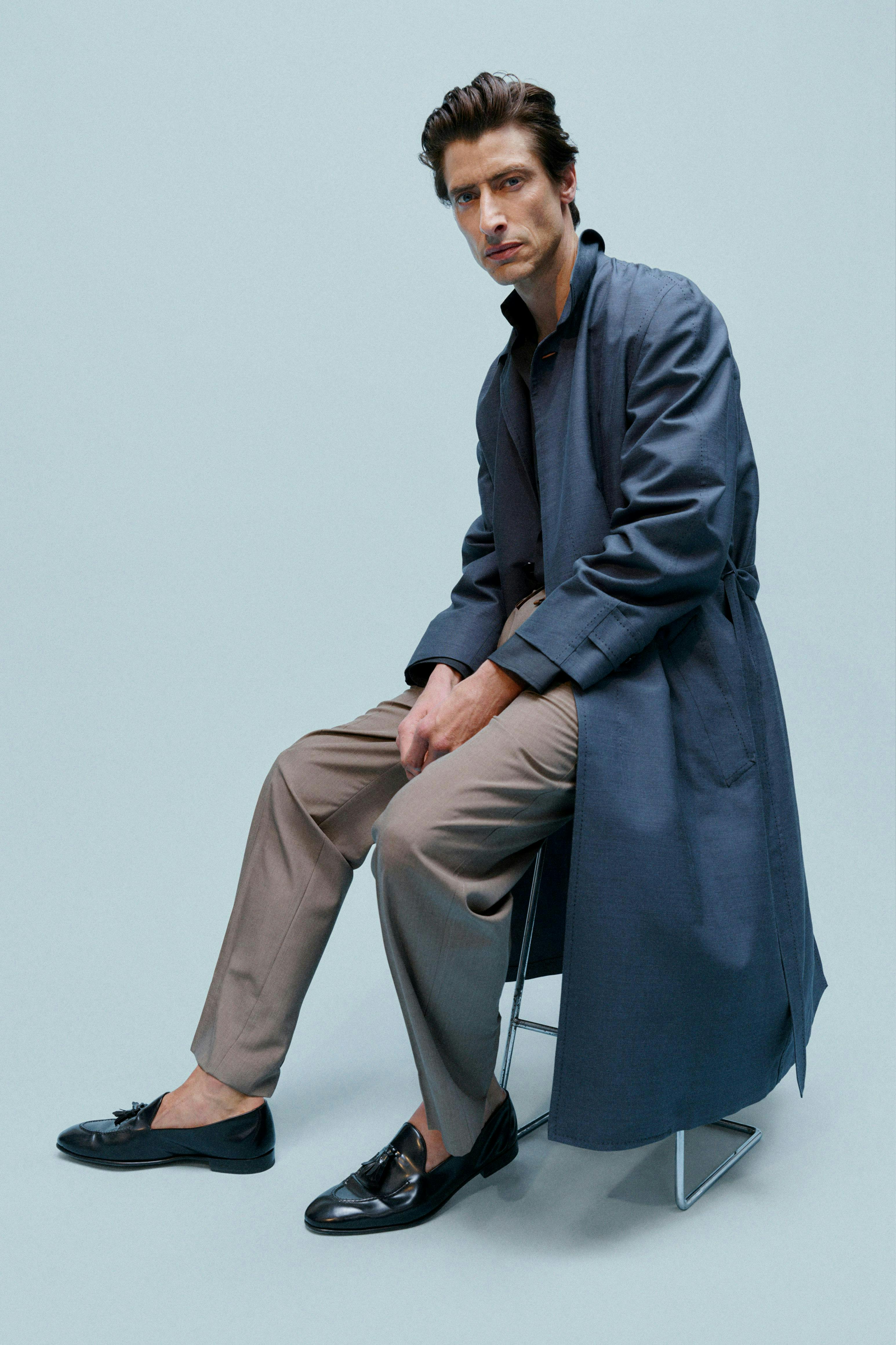 clothing coat shoe adult male man person overcoat blazer sitting